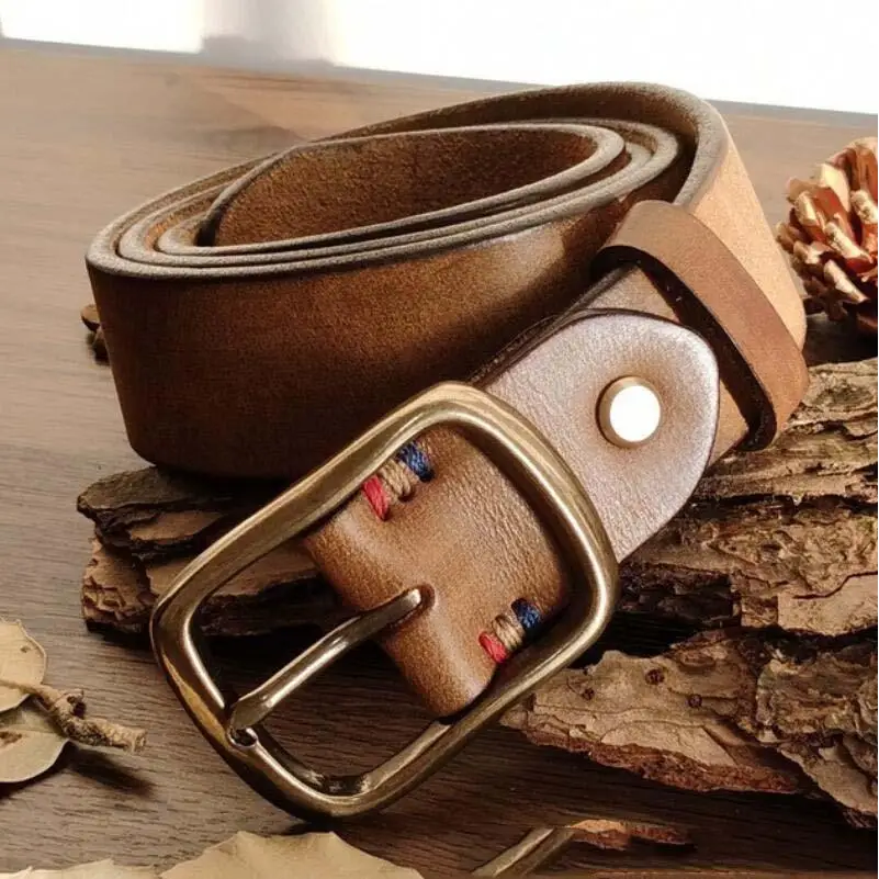 Assorted brown leather belts with polished brass buckles displayed for sale