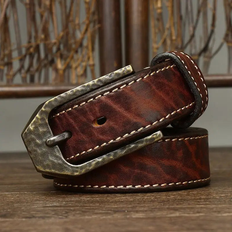Brown leather belt featuring a hammered metal decorative buckle for stylish wear