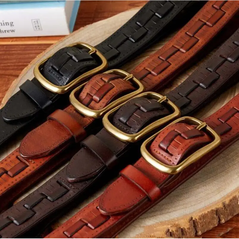 Assorted leather belts with brass buckles displayed with two-tone denim jeans for stylish wear