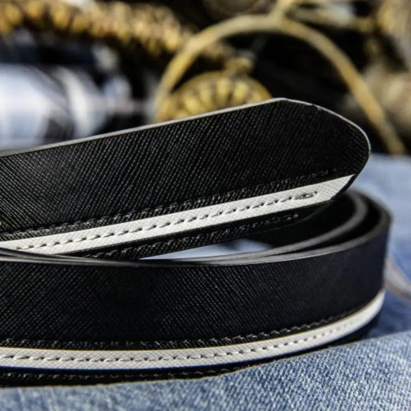Black leather belt with white trim, versatile accessory with silver buckle styling