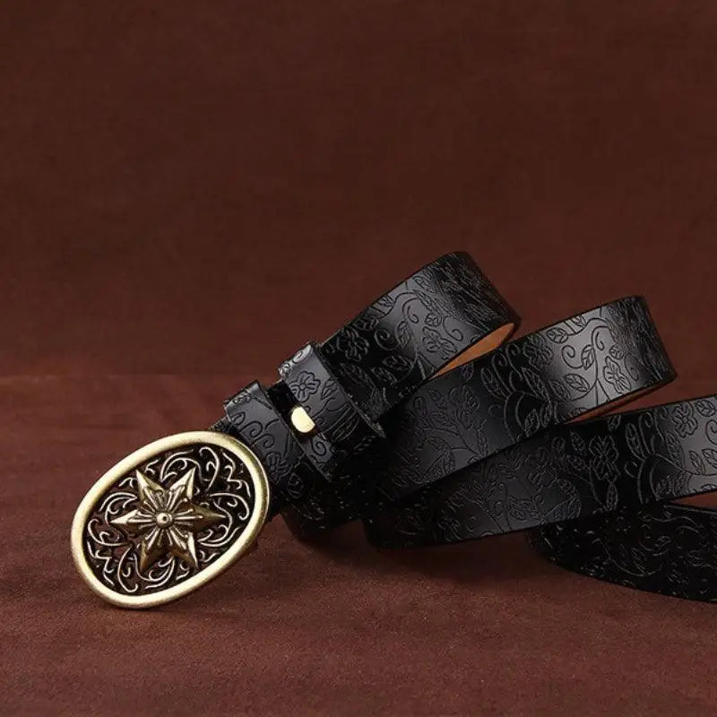 Embossed black Sanaa Leather Belt with ornate gold star buckle and floral pattern