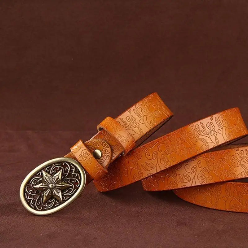 Embossed brown Sanaa Leather Belt with ornate gold star buckle and floral pattern