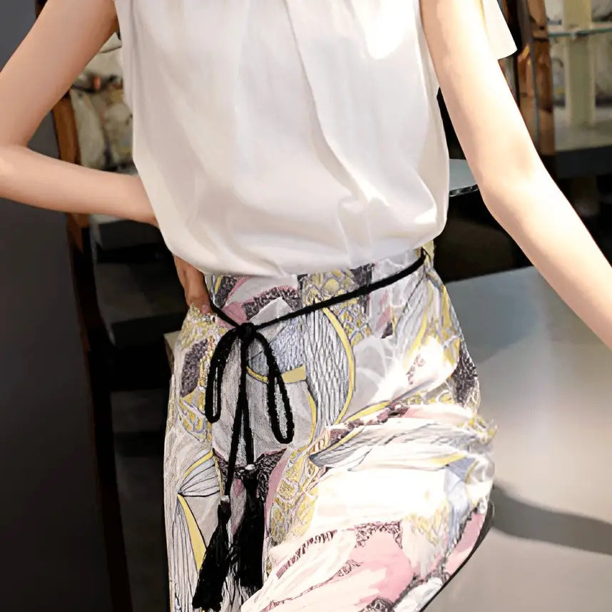 Woman’s white blouse and floral pants featuring Tumunia Model Tie Belt with tassel detailing