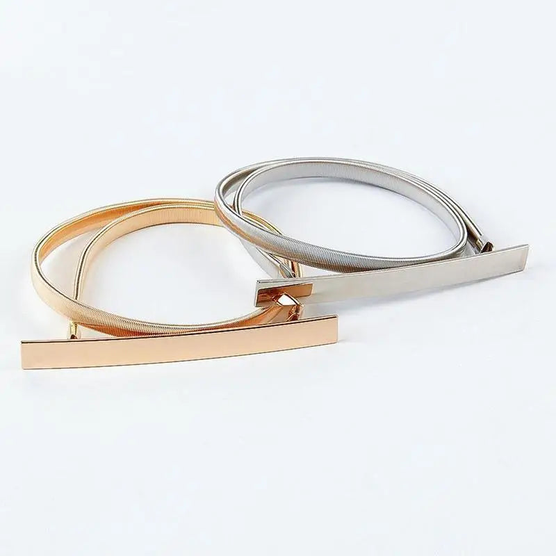 Gold and silver metal belts from Dhoxia Slim Belt collection with elegant gold-toned buckle
