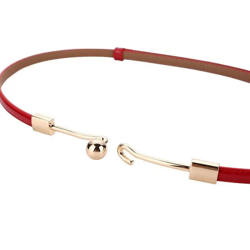 Red patent leather Wrona Belt with gold clasp showcasing subtle sophistication