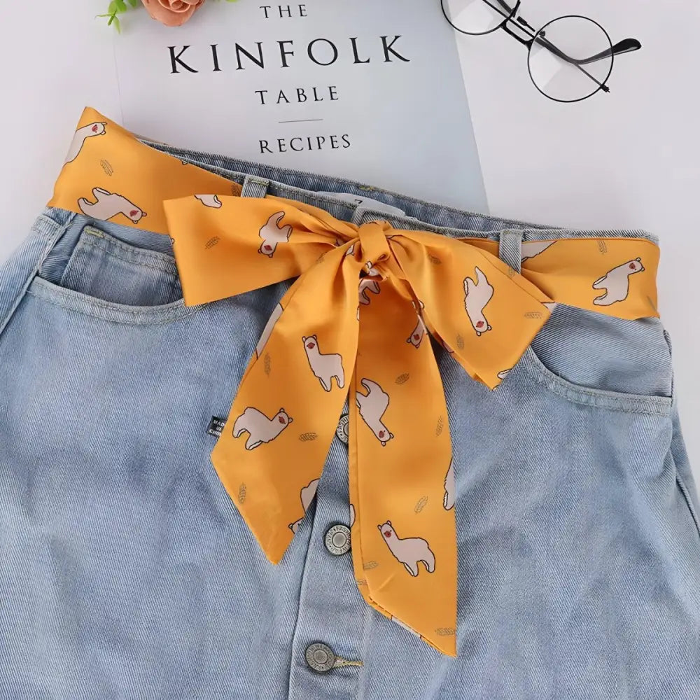 Light blue denim skirt with alpaca-patterned scarf belt inspired by South American design