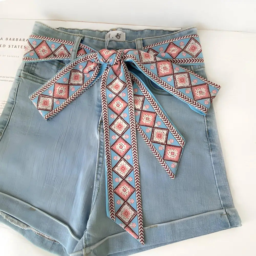Light blue denim shorts with borra scarf belt and patterned sash accessory