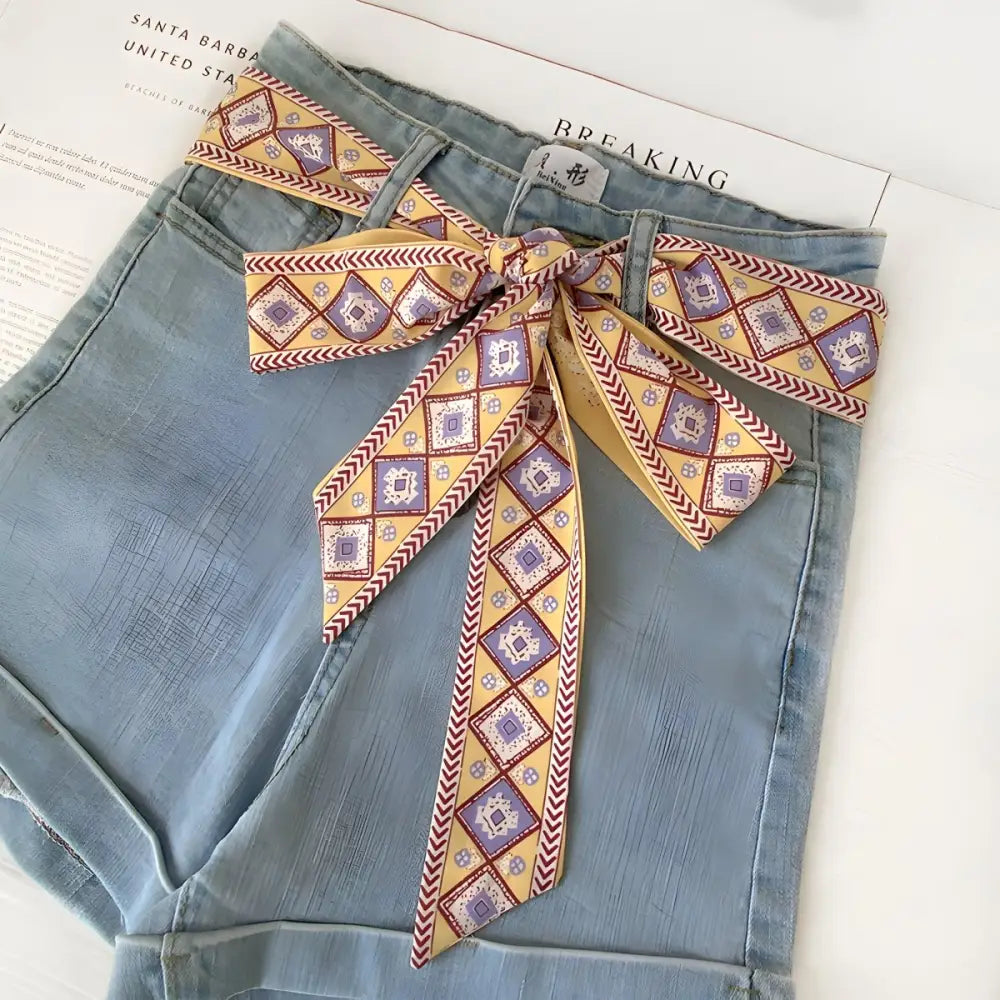 Light blue denim shorts with borra scarf belt and patterned sash for stylish summer wear