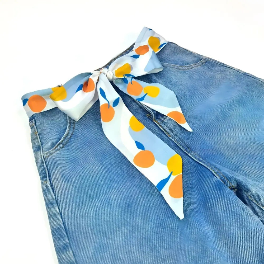 Light blue jeans with Citrus Burst Scarf Belt featuring orange fruit pattern for a stylish accessory