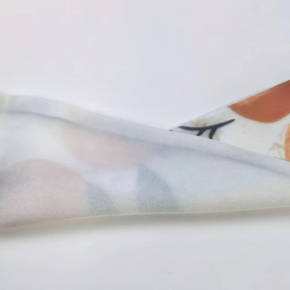 Folded patterned fabric showcasing a citrus abstraction scarf belt design for Blue Denim Jeans
