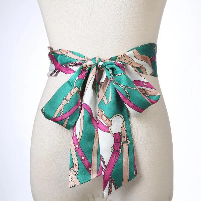Green, pink, and white patterned Betina scarf belt tied around mannequin’s waist