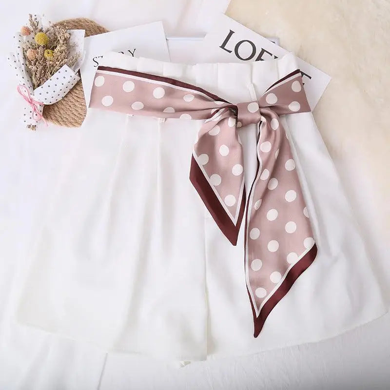 White shorts featuring a polka-dotted silk scarf-belt with a stylish polka-dotted silk design