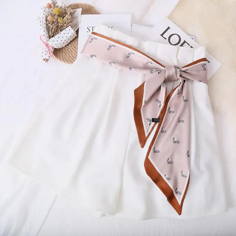 Elegant white dress with patterned silk scarf belt for a stylish look