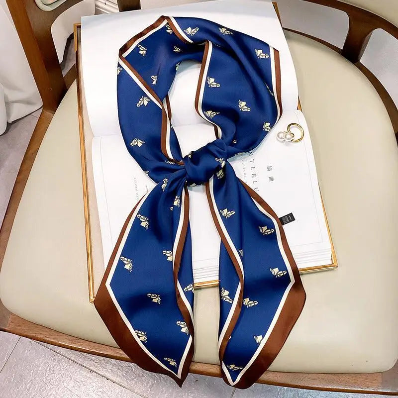 Elegant white dress with blue patterned silk scarf belt and brown trim for a stylish look