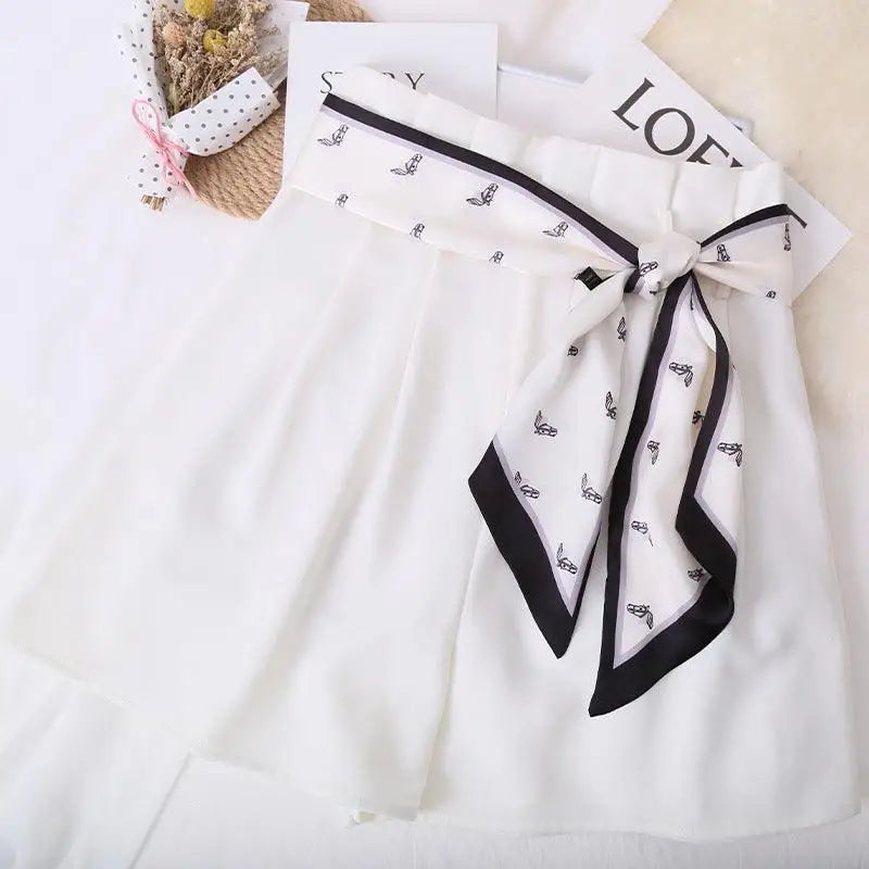 Elegant white dress with patterned silk scarf belt for a stylish look