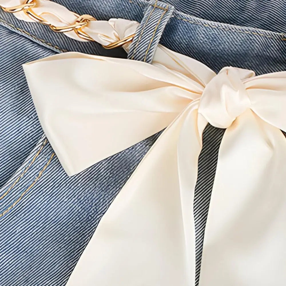 Denim jeans with satin bow and gold chain complement the Oriana silk scarf product