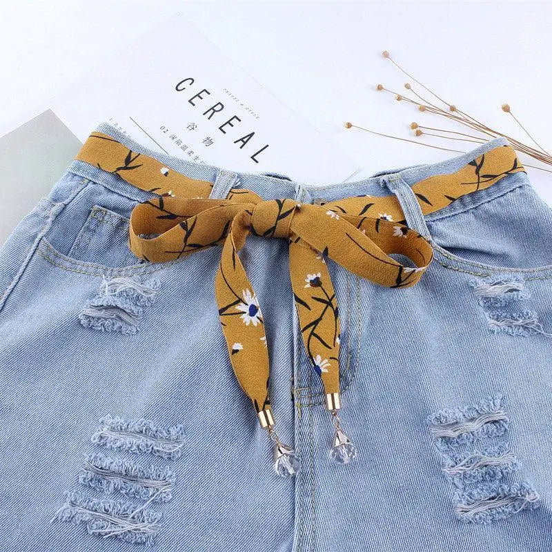 Distressed denim shorts with a floral scarf belt for casual style fashion Accessory