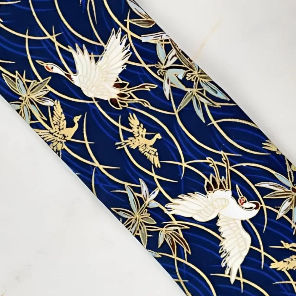 Blue fabric with crane and leaf pattern showcasing Obi Sash set and lanyard wallet design