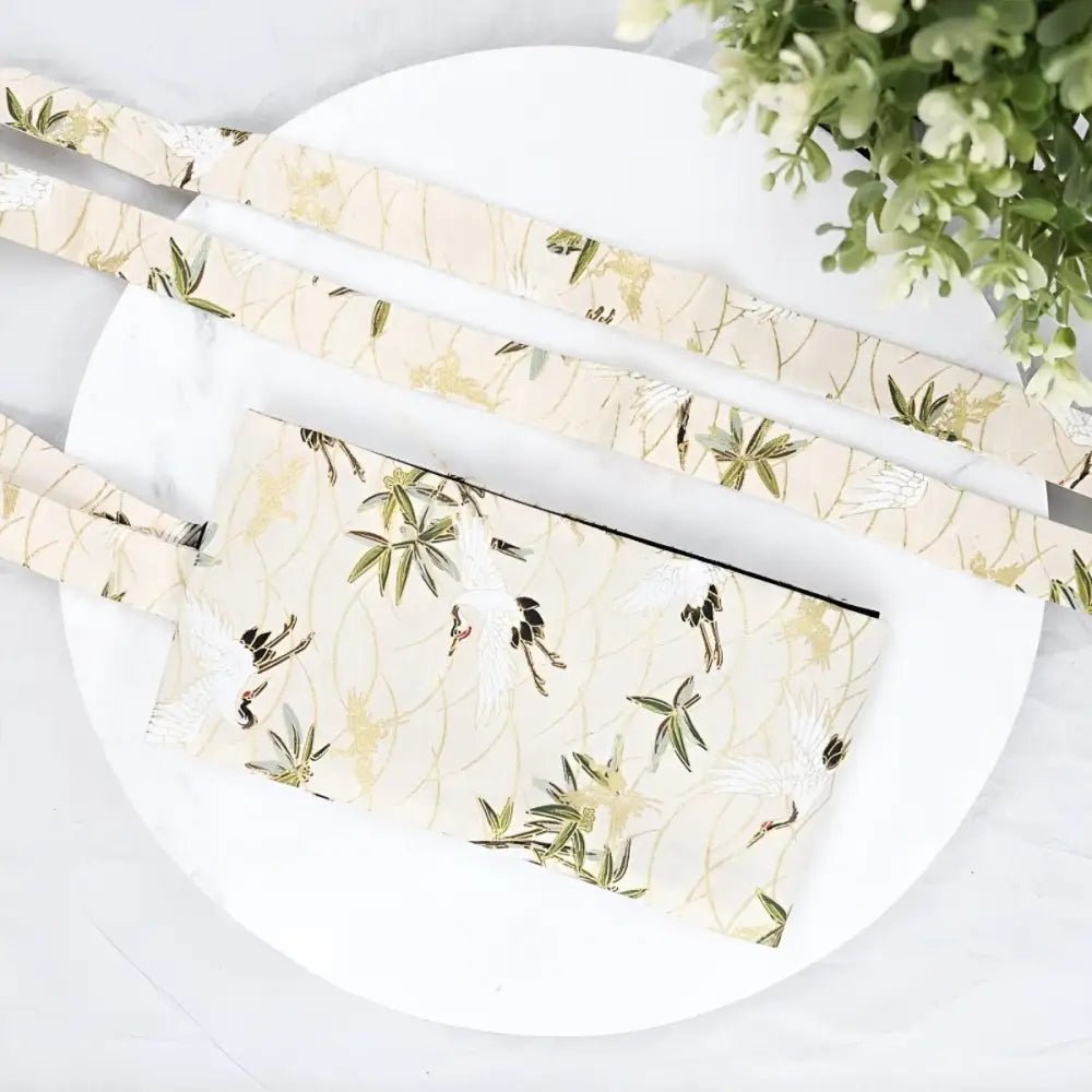 Cream crane patterned clutch with straps and a matching crane patterned obi belt