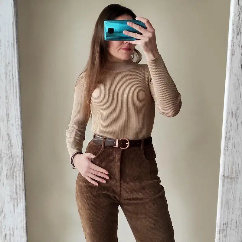 Woman wearing a ribbed turtleneck and corduroy pants in a casual outfit