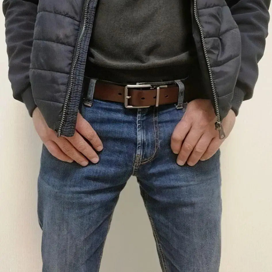 Man wearing jeans and a genuine leather reversible belt with silver buckle
