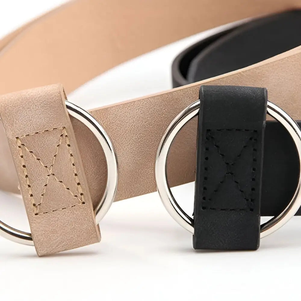 Taupe and brown leather belts with silver circular buckles displayed for product showcase