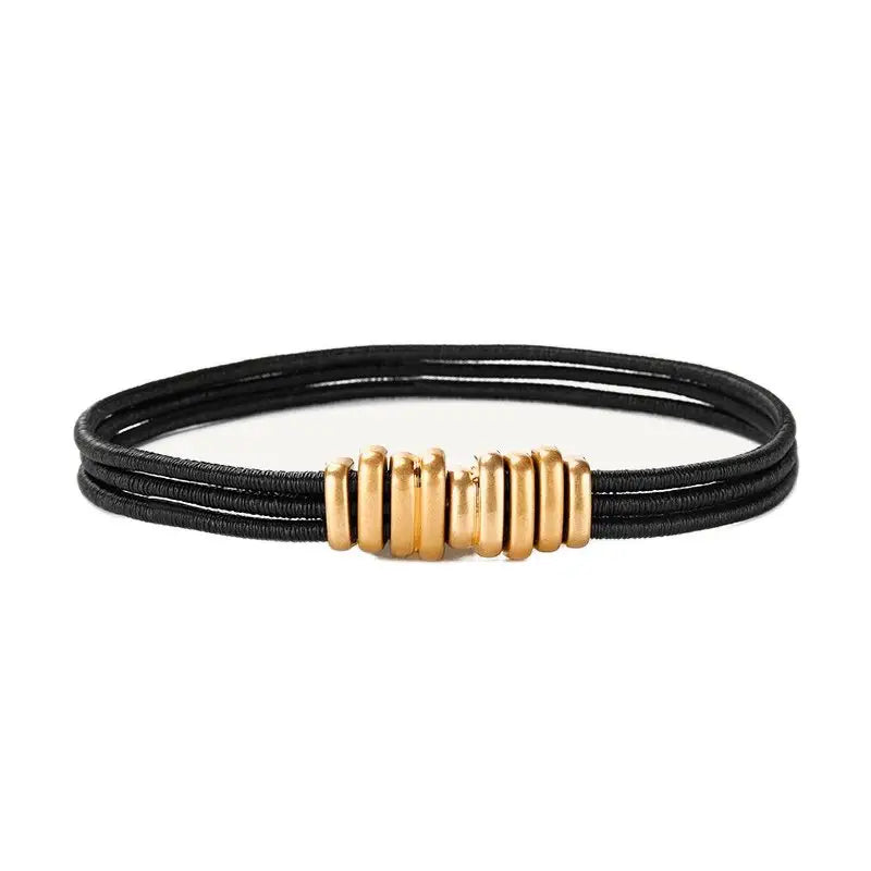 Black elastic bracelet with gold-colored beads displayed with trendy women’s Madona belt