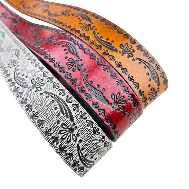 Set of three embossed leather belts with silver buckles displayed on a neutral background