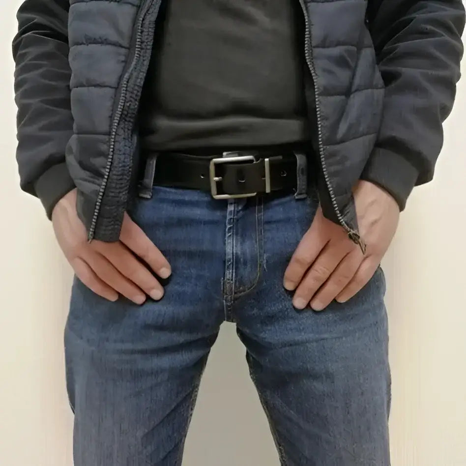 Man in jeans wearing a genuine leather reversible belt with metal and silver buckle