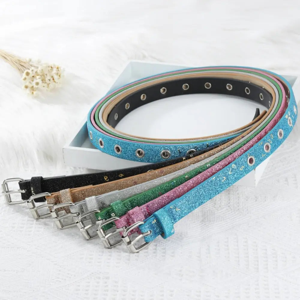 Colorful glittery belts with silver buckles and grommet details suitable for fashion styles