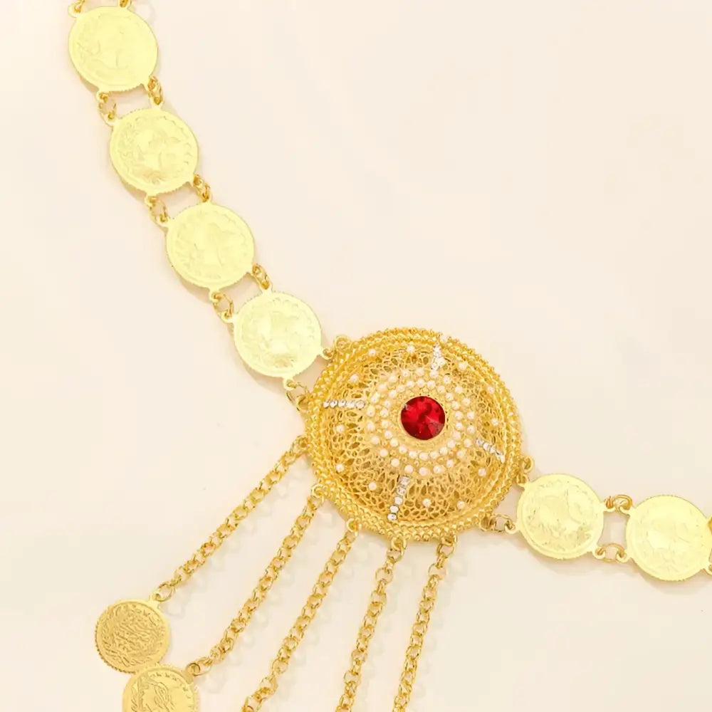 Gold coin and jewel-accented belly chain featuring a medallion with red center