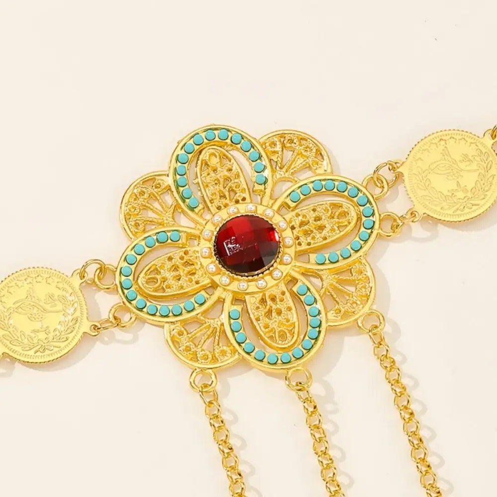 Gold-toned flower pendant with red gem and turquoise accents on Gold Coin Belt