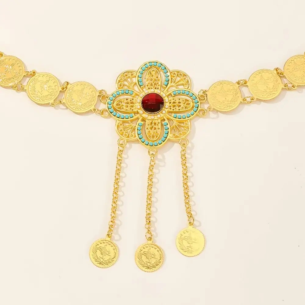 Gold-colored coin belt featuring an intricate floral centerpiece design