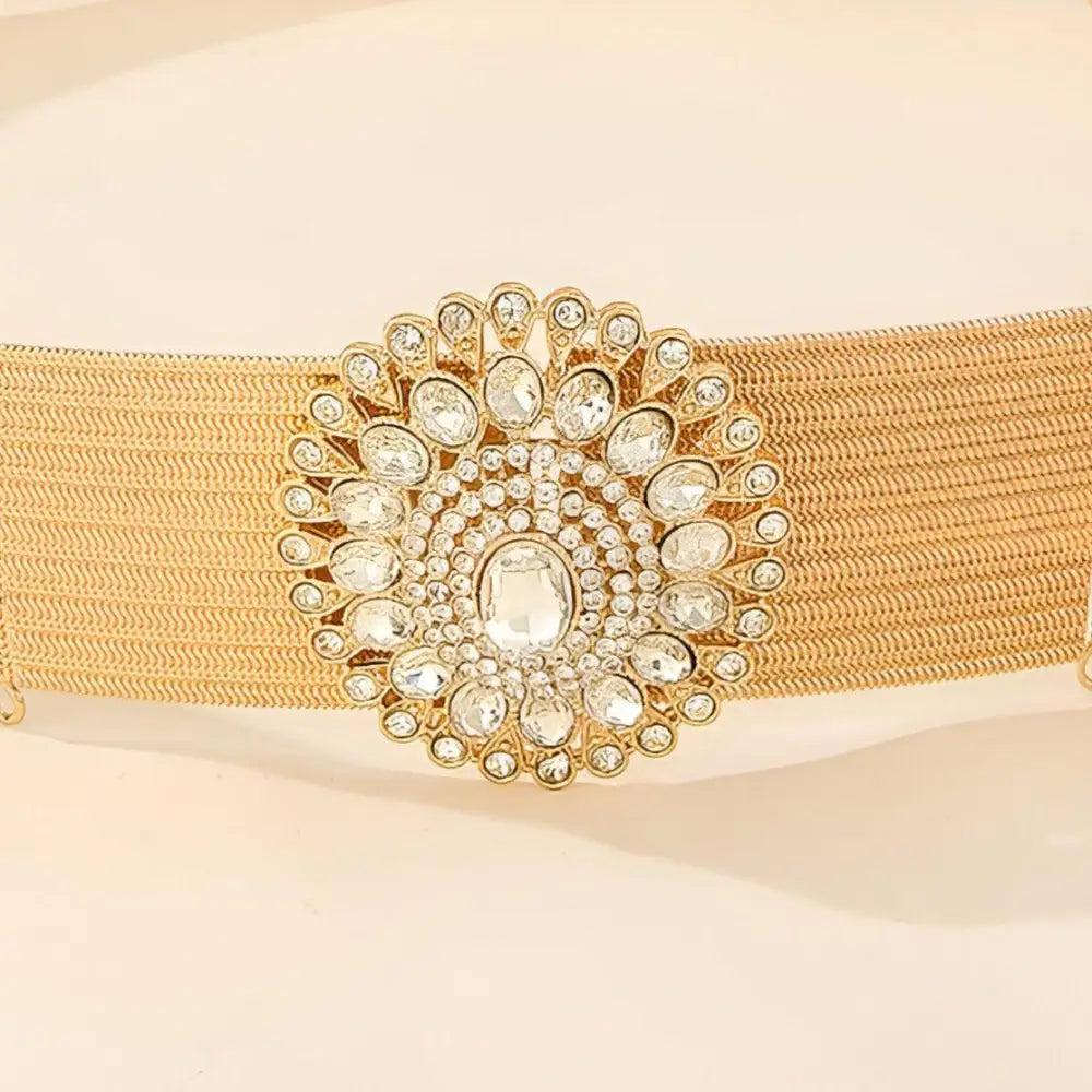 Gold-tone woven elastic belt featuring a jeweled circular buckle for elegant style