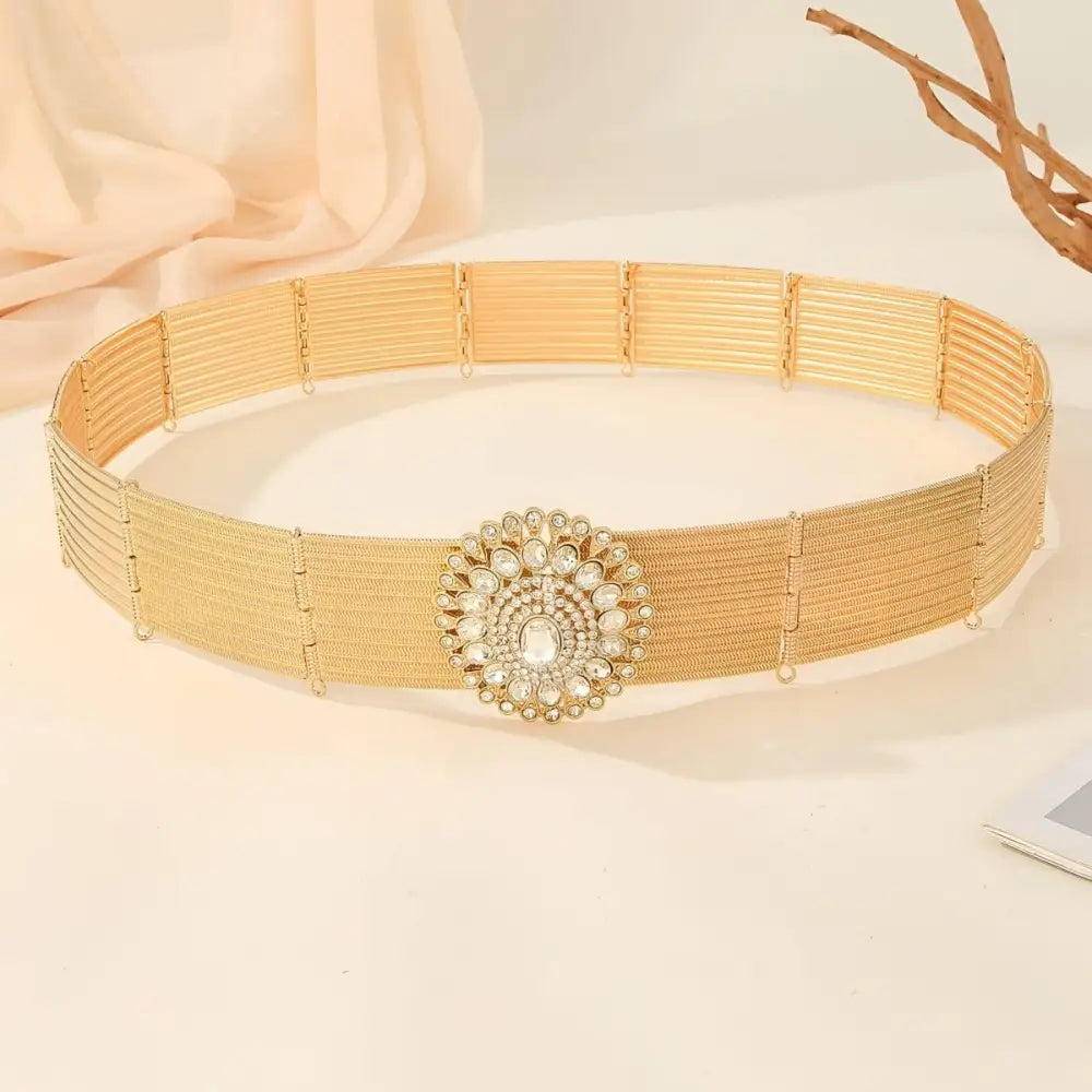 Gold-toned woven belt featuring a jeweled circular buckle for elegant fashion accessories