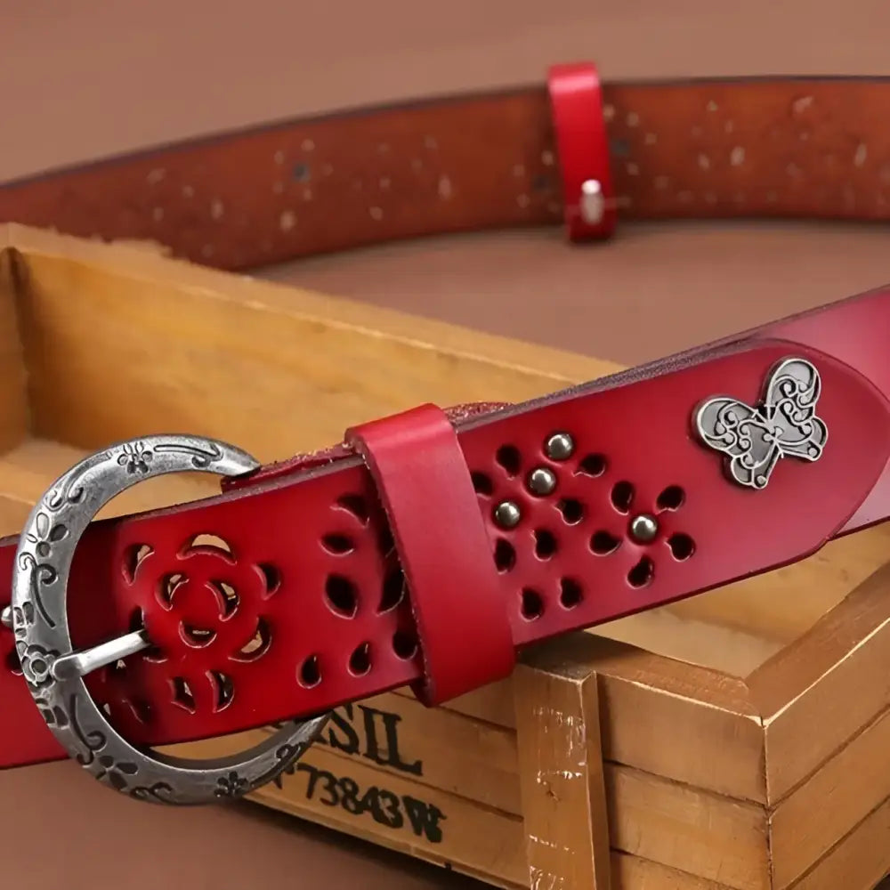 Red leather belt with floral cutouts and butterfly accent from Leather Belts with Decorative Buckles