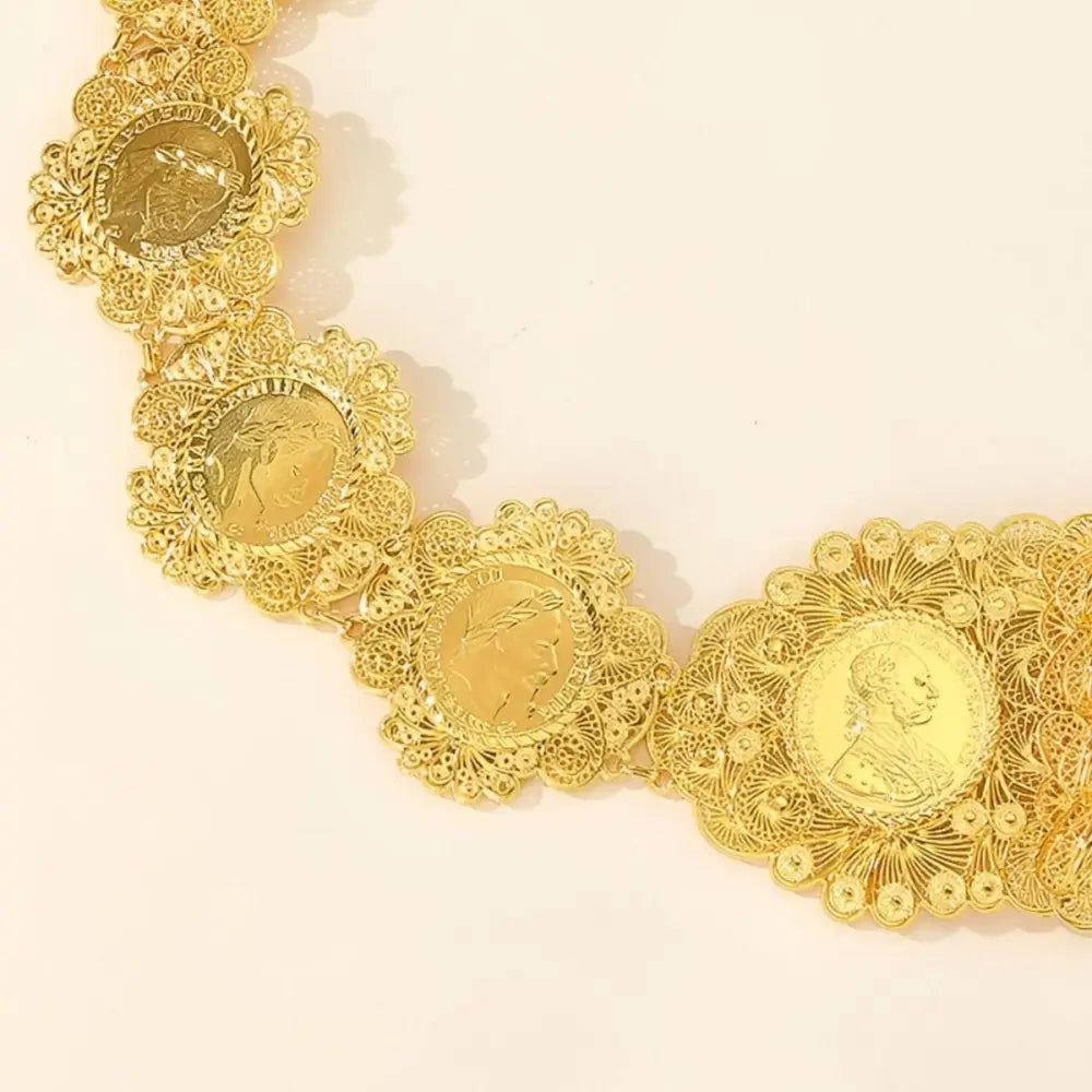 Ornate gold coin belt on patterned blue fabric showcasing intricate craftsmanship