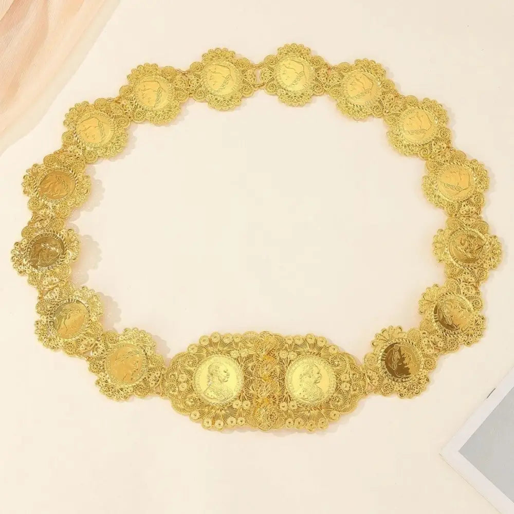 Ornate gold coin belt displayed on patterned blue fabric showcasing intricate craftsmanship