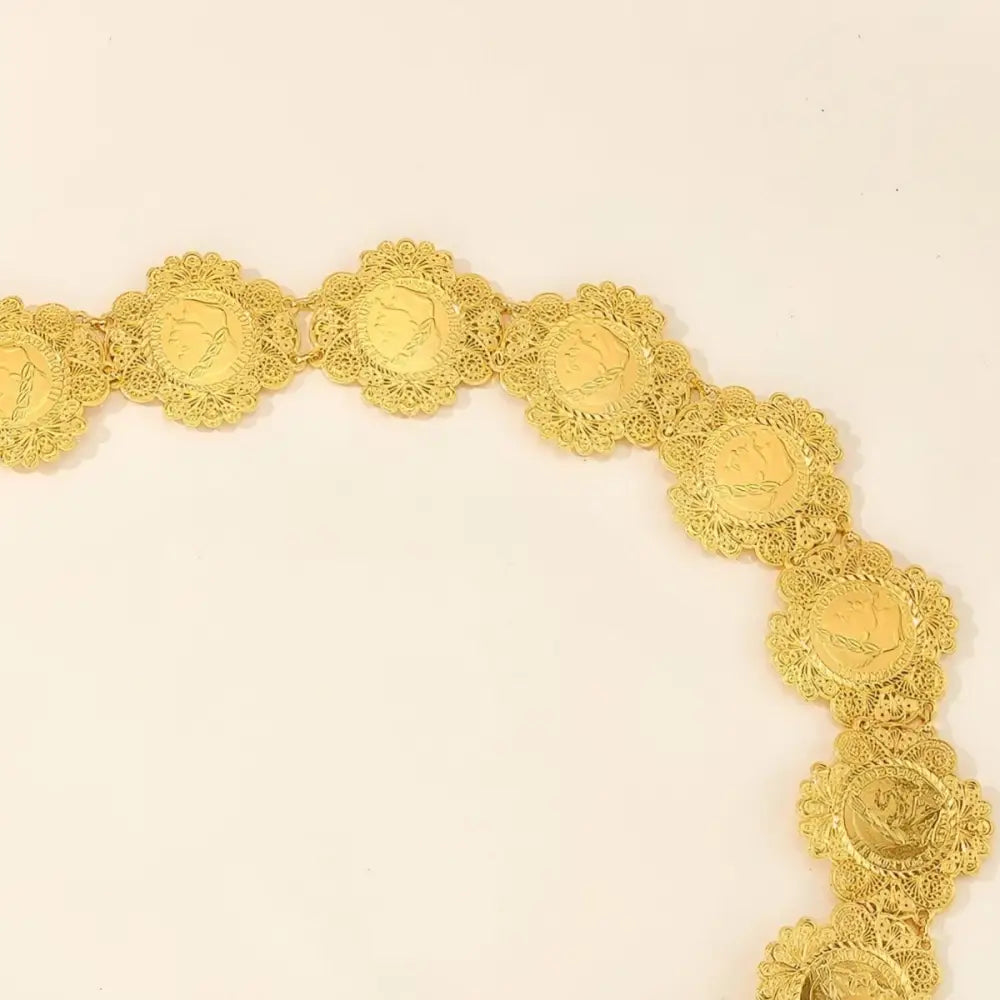Ornate Gold Coin Belt displayed on Patterned Blue Fabric showcasing intricate craftsmanship