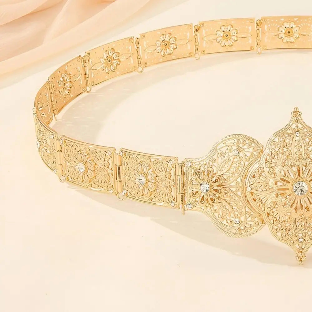Ornate gold metal belt featuring intricate detailing and a luxurious finish