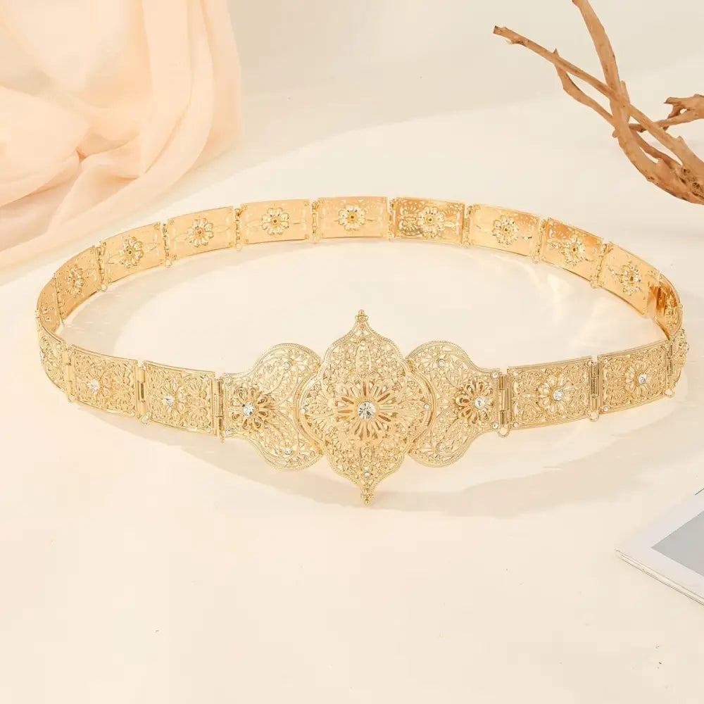 Ornate gold metal belt featuring intricate detailing and luxurious craftsmanship