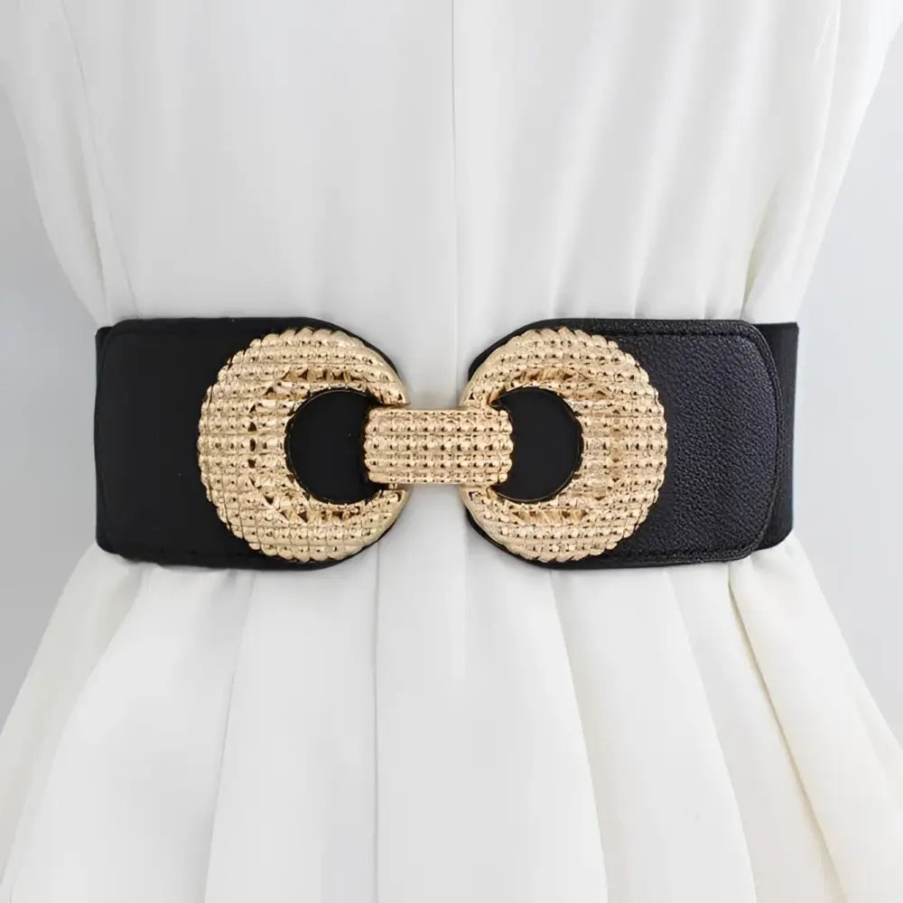 Black elastic belt with a gold circular buckle displayed with a pink shirt dress and cream belt