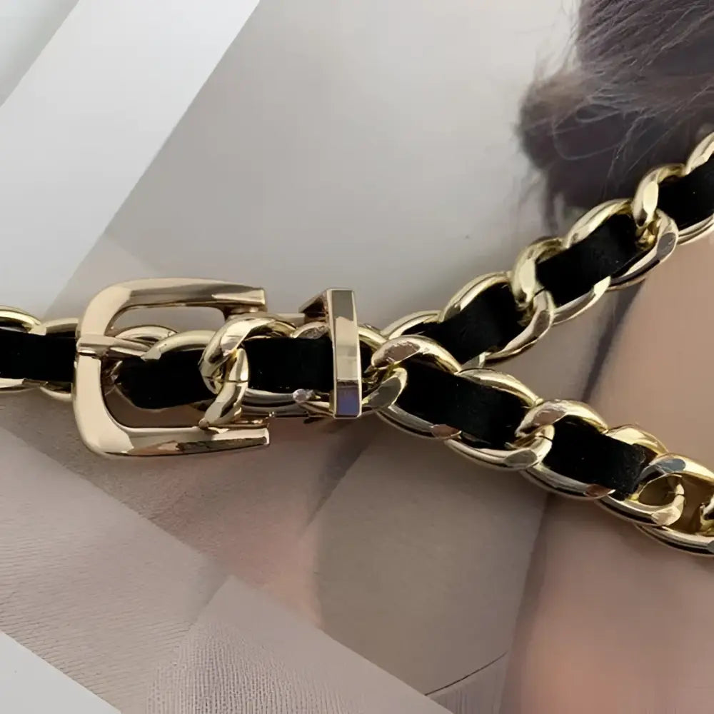 PrayOppé Model black blazer with gold chain belt and baseball cap accessory