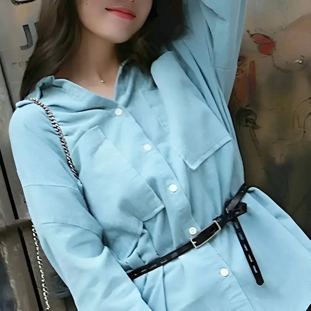 Light blue shirt paired with genuine leather belt featuring a silver buckle for elegant style