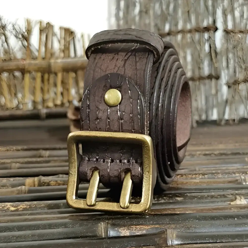 Set of four brown leather belts with brass buckles displayed neatly