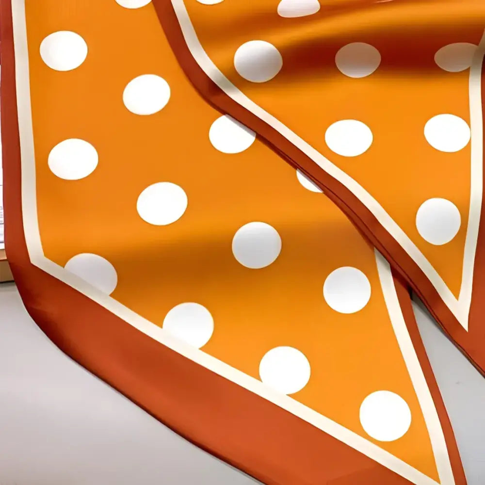Orange polka dot silk scarf-belt displayed with White Shorts in a stylish outfit